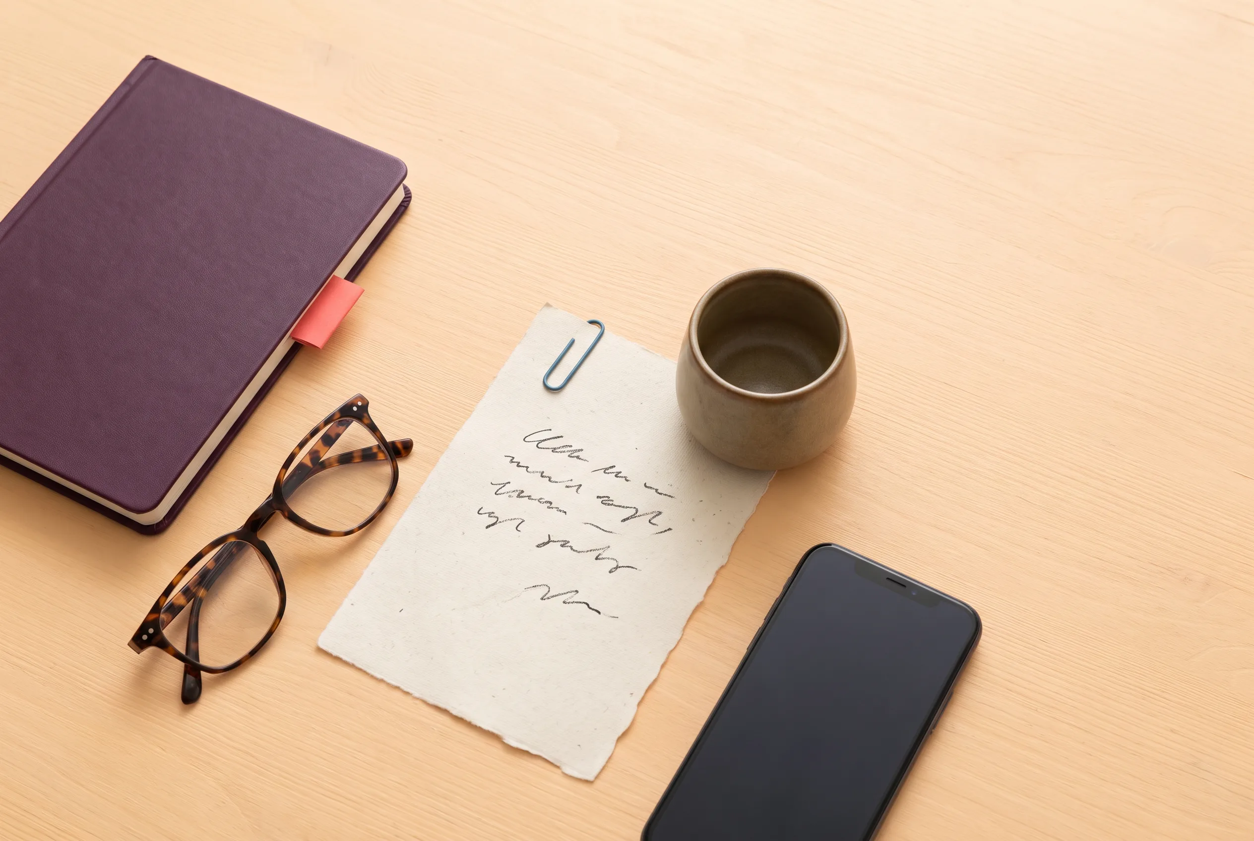 Notebook and phone arranged on a private desk